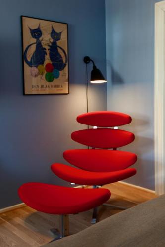a red chair in a room with a picture of cats at Hotel Alexandra in Copenhagen