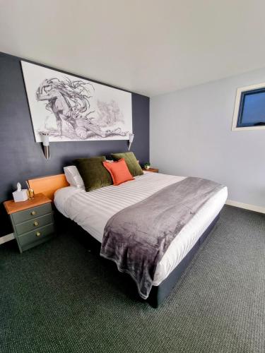 a bedroom with a large bed with a painting on the wall at Vineyard Haven in Grindelwald