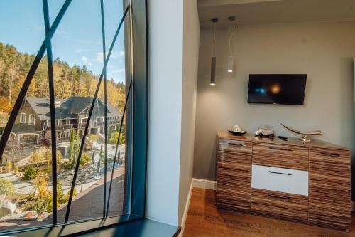 a living room with a large window and a tv at Norweska Dolina Family&Pet-friendly Resort in Szklarska Poręba
