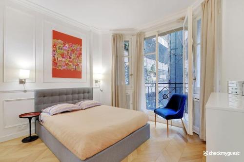 une chambre avec un lit et une chaise bleue dans l'établissement Luxury apartment 4pers George V, à Paris