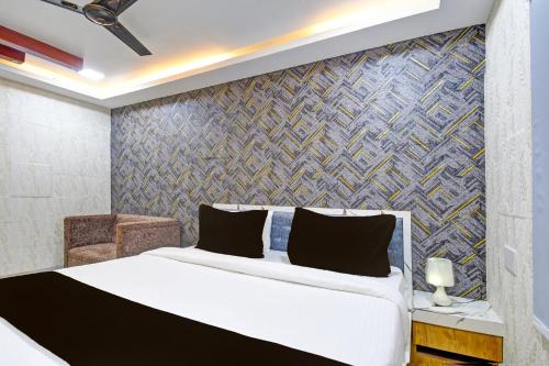1 dormitorio con cama y pared en OYO Maa Bhubaneswari Hotel, en Bhubaneshwar