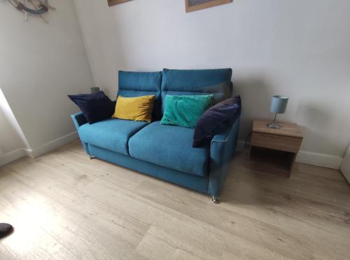a blue couch with pillows on it in a room at Castaline in Saint-Cast-le-Guildo