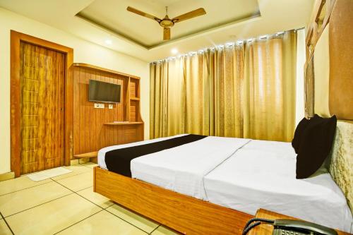 OYO Hotel Grand Signia في Zirakpur: غرفة نوم فيها سرير وتلفزيون
