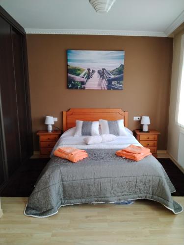 a bedroom with a large bed with orange pillows at A Casiña De Abaixo in A Guarda