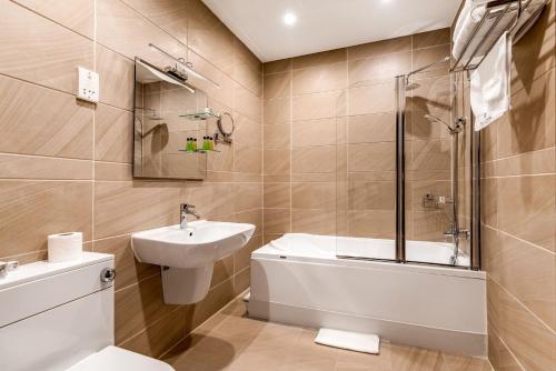 a bathroom with a sink and a toilet and a shower at Grand Sapphire Hotel & Banqueting in Croydon