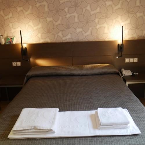 a bedroom with a bed with two towels on it at Hostal 4C Cuatro Caminos in Madrid
