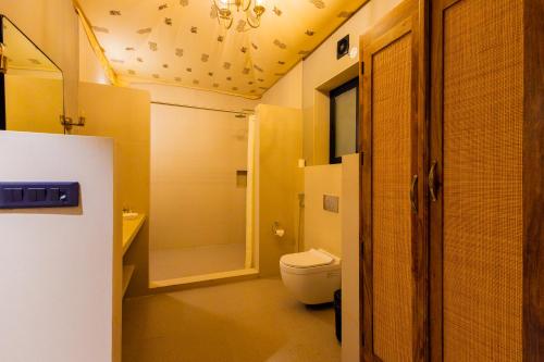 a bathroom with a toilet and a shower at Shahpura Gandharva Retreat, Sariska in Alwar