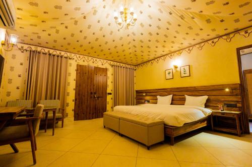 1 dormitorio con cama, lámpara de araña y mesa en Shahpura Gandharva Retreat, Sariska, en Alwar