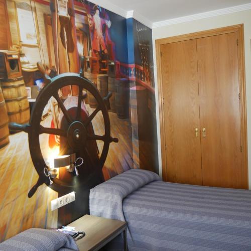 a room with a bed and a wooden wheel on the wall at Hostal 4C Cuatro Caminos in Madrid