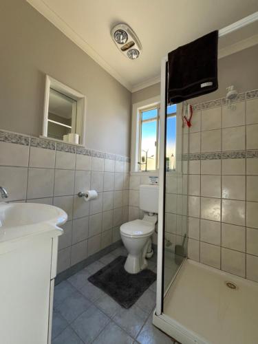 a bathroom with a toilet and a tv on the wall at Wombat Forest Country Retreat in Trentham East