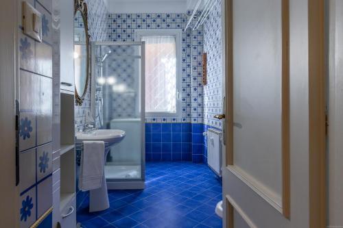 a blue bathroom with a sink and a toilet at HouSmart Cartoleria 8 in Bologna