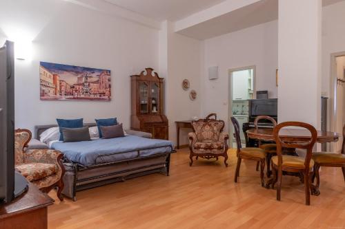 a living room with a couch and a table and chairs at HouSmart Cartoleria 8 in Bologna