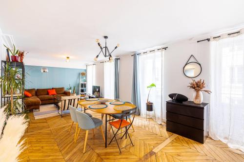 un salon avec une table, des chaises et un canapé dans l'établissement GuestReady - Homely Dwelling near Canal St Martin, à Paris