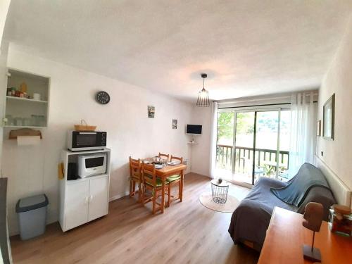 un salon avec une cuisine et une salle à manger dans l'établissement T2 à Vielle-Aure, 4 pers, balcon sud, parking, kitchenette équipée, proche commodités - FR-1-457-325, à Vielle-Aure