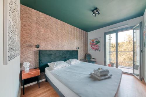a bedroom with a large bed and a large window at GuestReady - Apt près du Parc de la Tête d'Or in Lyon