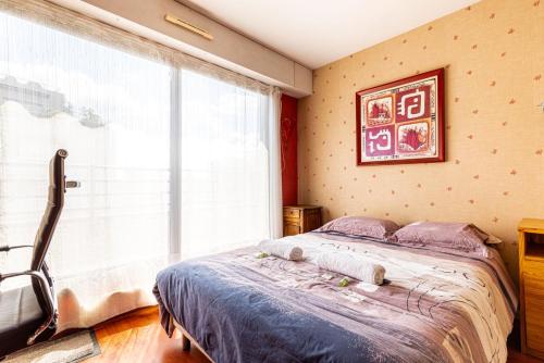 une chambre avec un lit et une grande fenêtre dans l'établissement GuestReady - Duplex avec terrasse privée, à Paris