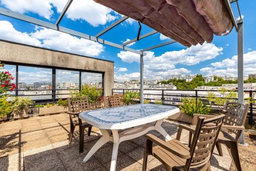 un patio avec une table et des chaises sur un balcon dans l'établissement GuestReady - Duplex avec terrasse privée, à Paris
