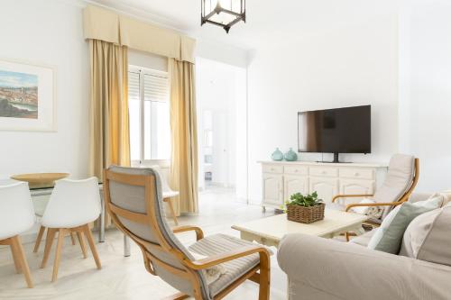 a living room with a couch and a tv at Luminoso y amplio piso en Chipiona 5 in Chipiona