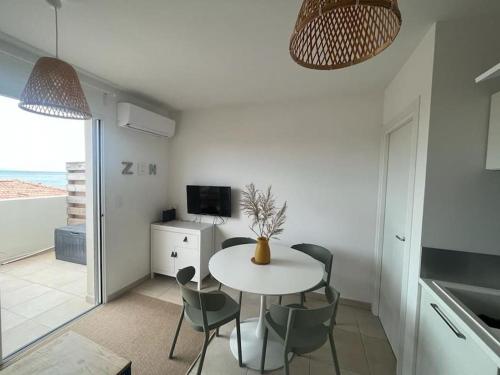 une cuisine et une salle à manger avec une table et des chaises dans l'établissement Appartement à 2 Pas de la plage, à Linguizzetta