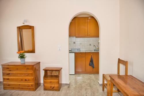 cocina con armarios de madera, mesa y banco en Villa Nikos Karamolegkos Kamari, en Kamari