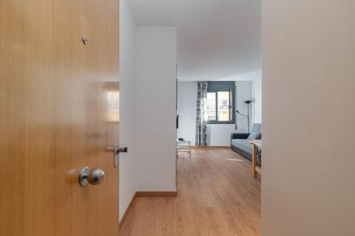 una puerta abierta a una sala de estar con sofá en GuestReady - Casa luminosa perto de Montjuïc en Barcelona