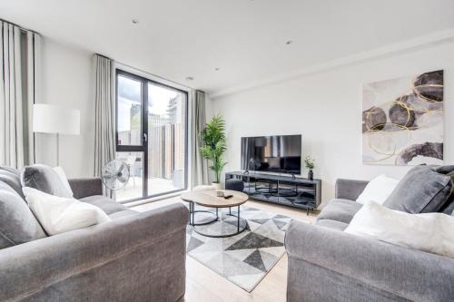 a living room with two couches and a table at GuestReady - Olympic Park City Living in London