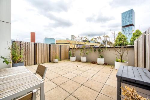 a rooftop patio with potted plants and a fence at GuestReady - Olympic Park City Living in London