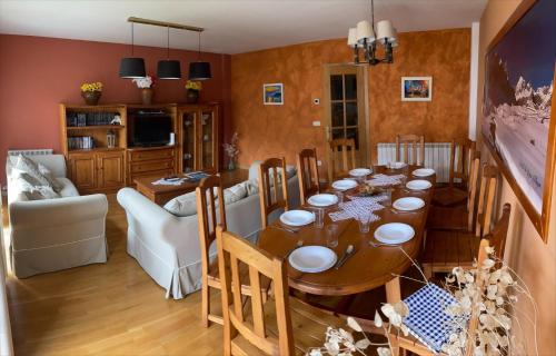 uma sala de jantar com uma mesa e uma sala de estar em Rincón de bachatos em Piedrafita de Jaca