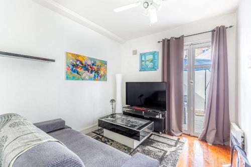 un salon avec un canapé et une télévision à écran plat dans l'établissement Bel Appartement Capucins - Victoire, à Bordeaux