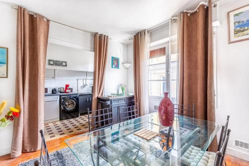 un salon avec une table en verre et une cuisine dans l'établissement Bel Appartement Capucins - Victoire, à Bordeaux