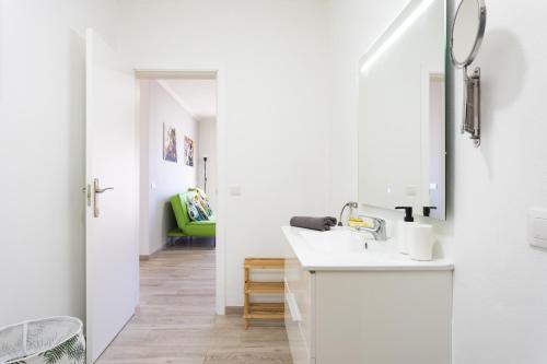 Un baño blanco con lavabo y espejo. en Home2Book Charming Apt Mountain Views Los Silos, en Los Silos