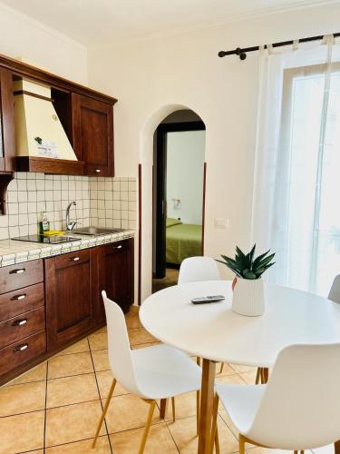 a kitchen with a white table and white chairs at Vicolo 35 Apartments in Trapani
