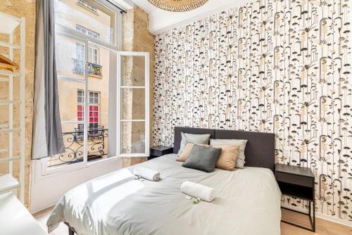 une chambre avec un lit avec deux serviettes blanches dessus dans l'établissement GuestReady - Bel Appartement Le Marais, à Paris