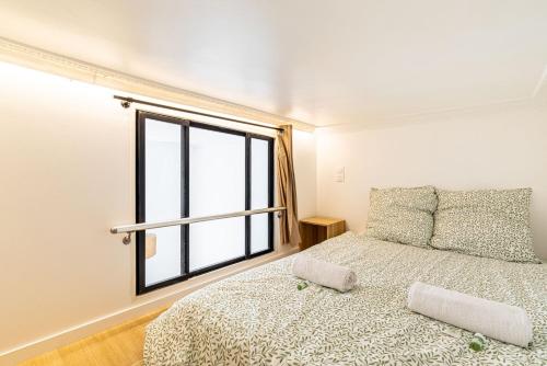 une chambre avec un lit et une grande fenêtre dans l'établissement GuestReady - Bel Appartement Le Marais, à Paris