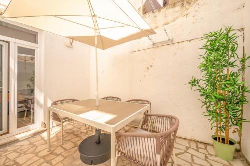una mesa y sillas con una sombrilla en el patio en GuestReady - Captain's residence R/C near Alfama, en Lisboa