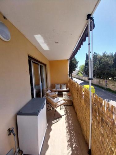 d'un balcon avec une table, des chaises et une clôture. dans l'établissement Appartement à 300m de la plage, à Fréjus