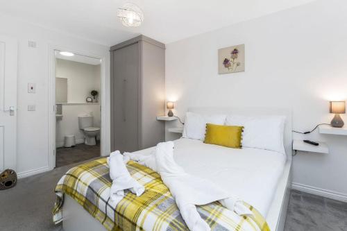 una camera con letto bianco e cuscino giallo di GuestReady - O Beehive em Edimburgo a Edimburgo