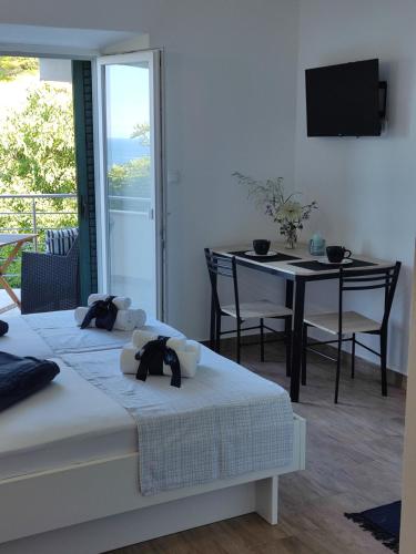 a room with two beds and a table with a television at Apartment Zagalo in Sveta Nedelja