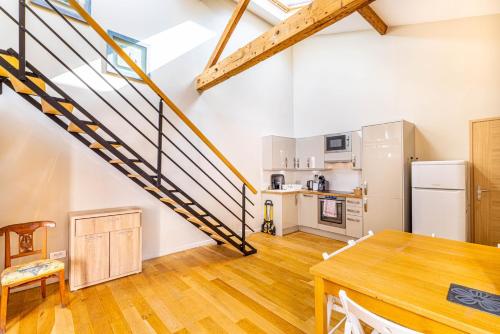 une cuisine et une salle à manger avec un escalier en mezzanine dans l'établissement GuestReady - Comfortable getaway near Paris, à Boulogne-Billancourt