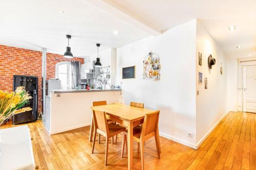 une cuisine et une salle à manger avec une table et des chaises en bois dans l'établissement GuestReady - Stay in the heart of Paris, à Paris