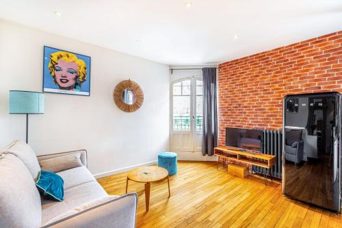un salon avec un canapé et un mur de briques dans l'établissement GuestReady - Stay in the heart of Paris, à Paris