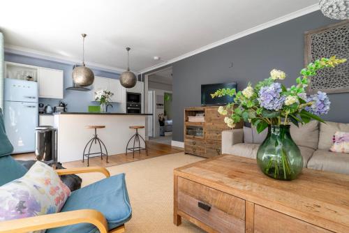 ein Wohnzimmer mit einer Vase aus Blumen auf einem Couchtisch in der Unterkunft GuestReady - The Perfect Getaway in Westminster in London