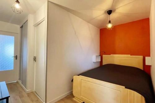 1 dormitorio con 1 cama con pared de color naranja en Appartement Vue Mer au pied de la plage de Merlimont, en Merlimont