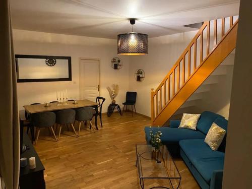 un salon avec un canapé bleu et une table dans l'établissement Charmante maison à Troyes avec terrasse et jardin clôturé, à Troyes