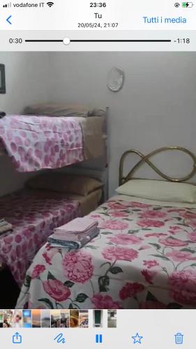 a picture of a bedroom with a bed with pink flowers at La casetta di Angelo! in San Giovanni in Marignano