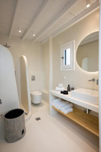 a white bathroom with a tub and a sink at Myconian Vision Villas in Elia Beach