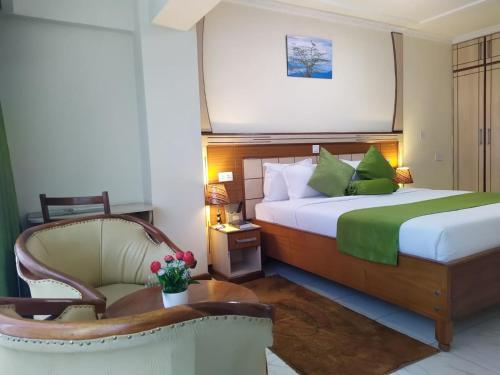 a hotel room with a bed and a chair at Empolos Hotel Nakuru in Nakuru