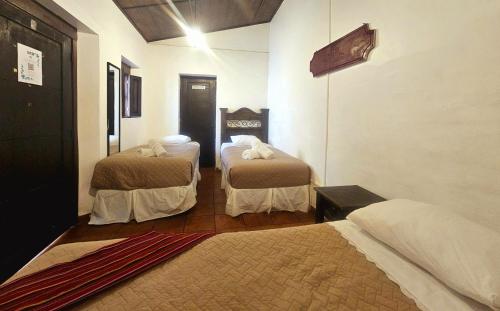 a hotel room with two beds in a room at Hotel Casa Nikté in Antigua Guatemala