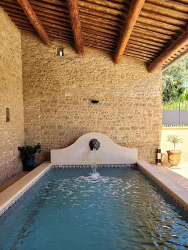 - une piscine avec une fontaine dans un bâtiment dans l'établissement Le Mas de l Olivier, à Saint-Geniès-de-Comolas