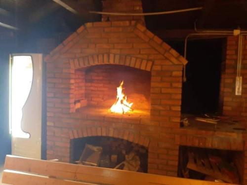 a brick fireplace with a fire in it at Vila Oaza mira in Vražići